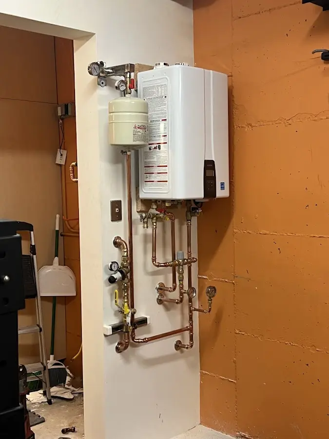 Plumbing technician inspecting water heater connections in Hilo